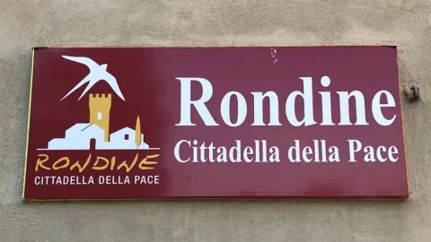 Insegna con scritto "Rondine, cittadella della pace"