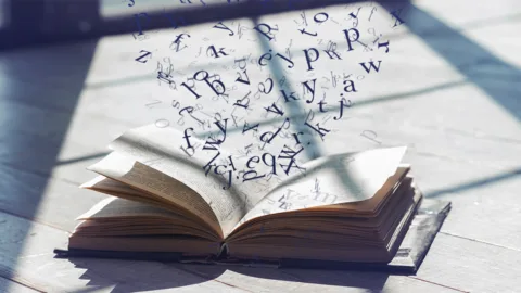 Un libro aperto con una grafica di lettere che escono dalle pagine