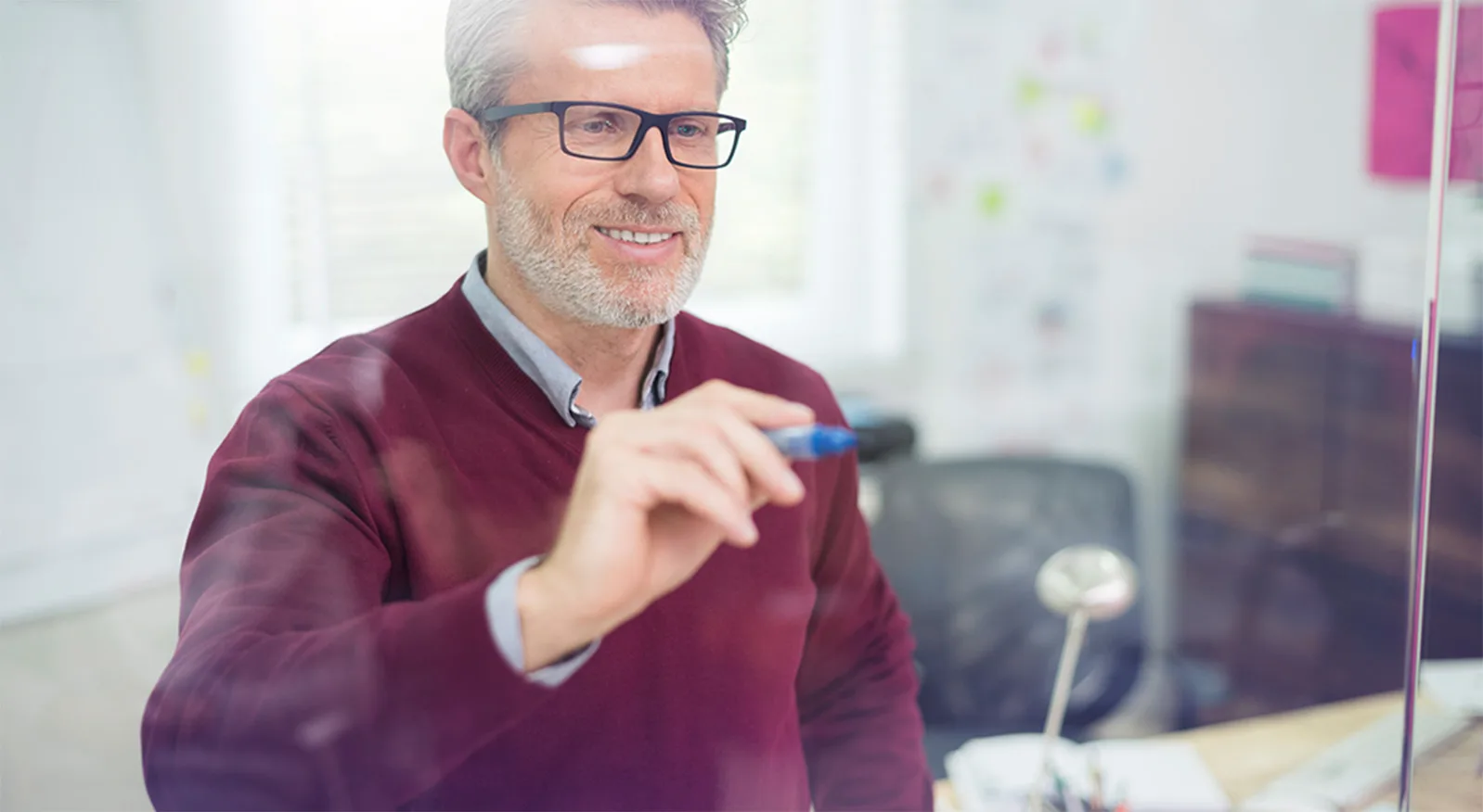 docente che scrive su parete di vetro